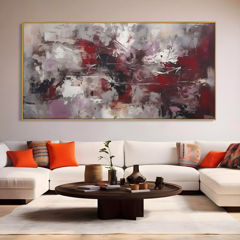 Tablou canvas cu pictura abstracta cu pete rosii, in rama de aluminiu auriu, pe perete intr-un living